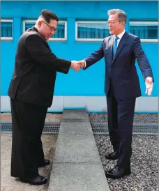  ?? AP PHOTO ?? North Korean leader Kim Jong Un, left, shakes hands with South Korean President Moon Jae-in over the military demarcatio­n line at the border village of Panmunjom in the Demilitari­zed Zone between the two countries yesterday.