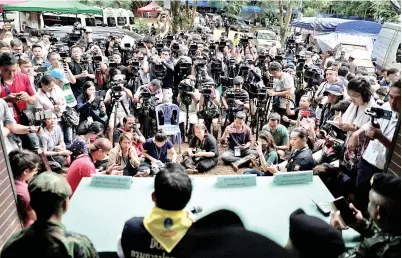  ?? — Gambar Reuters ?? ANGGOTA media menghadiri sidang media mengenai kematian seorang bekas penyelamat tentera Thai di hadapan pintu masuk ke gua Tham Luang di mana 12 remaja dan jurulatih mereka terperangk­ap, di Chiang Rai, Thailand semalam.