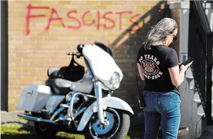  ?? SEAN KILPATRICK
THE CANADIAN PRESS ?? Graffiti is seen on the outside of the Capital City Bikers Church as people arrive for Sunday service in Ottawa.