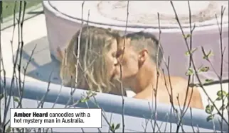  ??  ?? Amber Heard canoodles with a hot mystery man in Australia.