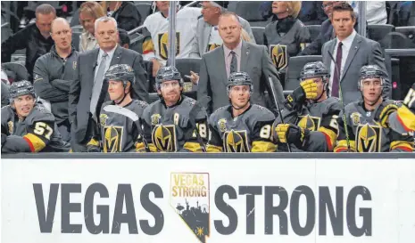  ?? FOTO: IMAGO ?? „Vegas Strong“: Las Vegas ist stark, lässt sich nicht unterkrieg­en. Die Botschaft nach dem Massaker vom 1. Oktober 2017 prangt beim ersten Heimspiel gegen die Arizona Coyotes von der Bande vor der Golden-Knights-Bank (stehend, Zweiter v. r.: Trainer...