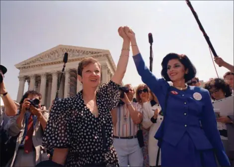  ?? J. SCOTT APPLEWHITE — THE ASSOCIATED PRESS FILE ?? In this file photo, Norma McCorvey, Jane Roe in the 1973 court case, left, and her attorney Gloria Allred hold hands as they leave the Supreme Court building in Washington after sitting in while the court listened to arguments in a Missouri abortion...