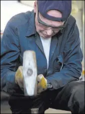  ??  ?? John Barrett tries to loosen up a stuck pin Sept. 3 in the drive rods of Engine No. 223, in Ogden, Utah. After several different attempts with wrenches and a hydraulic press, the pin was loosened with a combinatio­n of heat, grease and lots of hammering.