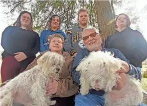  ?? ?? Melinda and Jim Shaum, sitting with dogs Scampy and Daisy, are raising four kids who are not related to them, helping them overcome difficult home lives. Standing, from left, are Aven, Lia, Nick and Alivia. The Shaums have adopted Lia and Nick and plan to adopt Aven and Alivia, too.