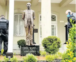  ?? AP ?? Bullet holes are visible on a column behind a statue of Cuban independen­ce hero José Martí as Secret Service officers investigat­e after police say a person with an assault rifle opened fire at the Cuban Embassy, Thursday, April 30, in Washington.