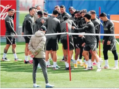  ?? JUAN CARLOS HIDALGO / EFE ?? Los jugadores del Atlético hacen un pasillito en el entrenamie­nto con Simeone atento a la escena.