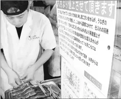  ??  ?? Restaurant workers prepare grilled eel at a shop in Tokyo’s Meguro Ward.