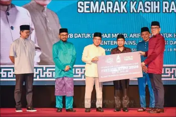  ?? — Informatio­n Department photo ?? Harun (third left) presenting the STbM Festival funding to Kota Kinabalu District bducation lfficer Suhaimi Matshah, while Raisin (fourth left) looks on.