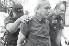  ??  ?? National Democratic Front of the Philippine­s consultant Vicente Ladlad is escorted by the police following his arrest for illegal possession of firearms. PHILSTAR.COM