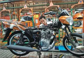  ?? PROVIDED TO CHINA DAILY ?? A QJiang Motorcycle employee works on an assembly line in Taizhou, Zhejiang province.