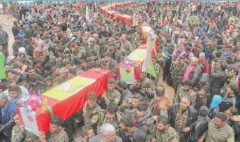  ??  ?? Fighters from the predominan­tly Kurdish Syrian Democratic Forces carry the coffins of their comrades killed Tuesday by a misdirecte­d airstrike by the U. S.- led coalition.
| HAWAR NEWS AGENCY VIA AP