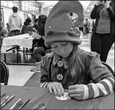  ?? JULIE DRAKE/Valley Press ?? Ten-year-old Alexia Ortega colors the background of a snowman ornament Monday afternoon at Antelope Valley High School’s sixth annual Lopes Christmas Luncheon.