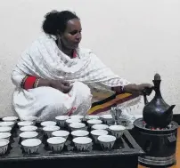  ??  ?? Sisaynesh Gebeyaw with the jebena (coffee pot) on a charcoal brazier and cups at the ready.