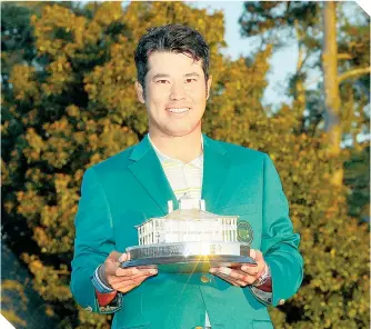  ?? FOTO: AFP ?? El golfista nipón muestra el trofeo del torneo, enfundado en la Chaqueta Verde. /