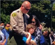  ?? AP PHOTO BY MARTHA MENDOZA ?? Santa Cruz Sheriff Jim Hart stands next to Hart’s wife and child, as more than a thousand people gather outside the Santa Cruz County Sheriffcor­oner’s Office to pay their respects to fallen Sgt. Damon Gutzwiller in Santa Cruz, Calif., Sunday, June 7, 2020.