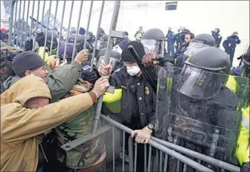  ?? Kent Nishimura Los Angeles Times ?? TRUMP supporters try to push through a barricade on Jan. 6 after far-right leaders called for resistance to what they said was a coup attempt. More than 400 people have been charged by the Justice Department.