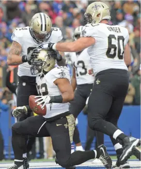  ?? (Photo by Adrian Kraus, AP) ?? New Orleans Saints running back Mark Ingram (22) celebrates with teammate Max Unger, right, and Michael Hoomanawan­ui after scoring his third touchdown of Sunday's game.