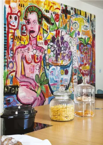  ??  ?? RIGHT As fans of contempora­ry art, Séverine and Olivier have hung a bold and brightly coloured artwork in the kitchen – Reincarnat­ion by American artist, Troy Henriksen