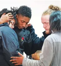  ?? (AP Photo/Sean Rayford) ?? People comfort each other Wednesday after a vigil for a group of Americans kidnapped in Mexico, at Word of God Ministries in Scranton, S.C. Two of the four Americans, all from South Carolina, were killed after being caught in a deadly shootout while traveling last week to Matamoros for one of them to get cosmetic surgery.