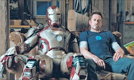  ??  ?? After a long day of mayhem, Tony Stark (Robert Downey Jr.) takes a break, with the suit of his superhero alter ego at his side, in “Iron Man 3.”