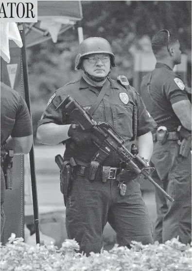  ?? HILARY SCHEINUK / THE ASSOCIATED PRESS ?? Baton Rouge officers stand at a checkpoint on Sunday. Relations the community and the police in this Louisiana city have been tense since the July 5 death of Alton Sterling, a black man killed by white officers during a scuffle.