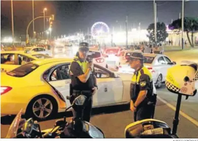  ?? ALBERTO DOMÍNGUEZ ?? Dos policías locales de Huelva con el ferial de las Colombinas al fondo.