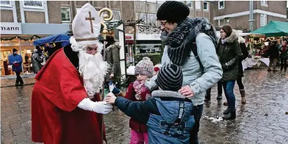  ?? NGZ-FOTOS: A TI ?? Im wärmenden Nikolausko­stüm verteilte Christoph Demuth in Büttgen Leckereien an die kleinen Besucher des Spekulatiu­smarktes.