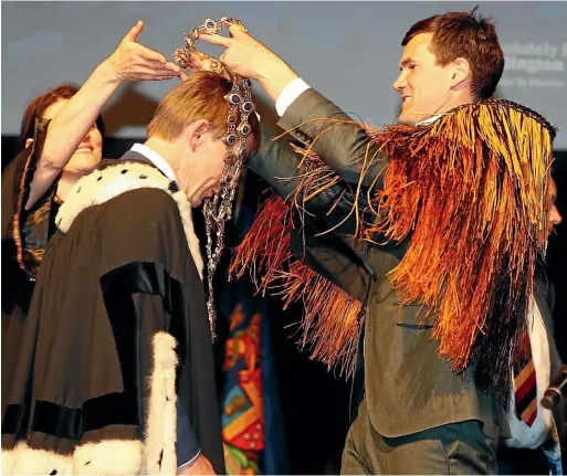  ?? ROBERT KITCHIN/STUFF ?? Wellington’s new mayor Andy Foster receives the mayoral chains from predecesso­r Justin Lester.