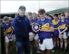  ??  ?? Hugh Kenny presents Carnew captain Ruairi O’Brien with the under-15 ‘C’ cup after their victory over Michael Dwyers.