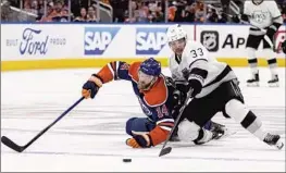  ?? Jason Franson Associated Press ?? VIKTOR ARVIDSSON, right, of the Kings battles for the puck with Edmonton’s Mattias Ekholm. The Kings gave up three power-play goals in a 7-4 loss in Game 1.