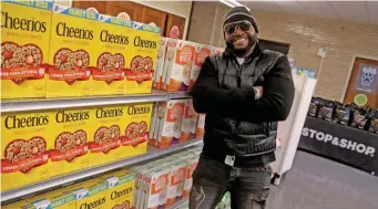  ?? MATT sTonE / HErAld sTAFF ?? BIG HIT: David Ortiz poses in the food pantry at Jeremiah E. Burke High School in Dorchester. Ortiz opened the food pantry on Tuesday.