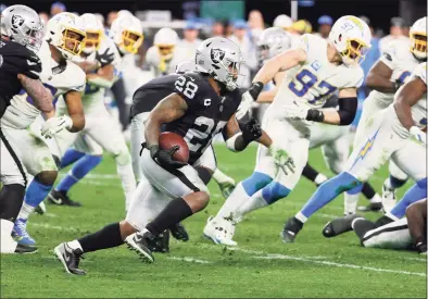  ?? Ethan Miller / Getty Images ?? Running back Josh Jacobs, No. 28, of the Las Vegas Raiders runs against the Los Angeles Chargers in overtime of their game at Allegiant Stadium on Jan. 9, in Las Vegas, Nevada. The Raiders defeated the Chargers 35-32, the latest game shown on NBC Sports’ “Sunday Night Football.”