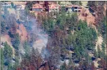  ?? CP PHOTO JONATHAN HAYWARD ?? Smoke and fire retardant is seen along a neighbourh­ood in Lake Country, B.C., Sunday.