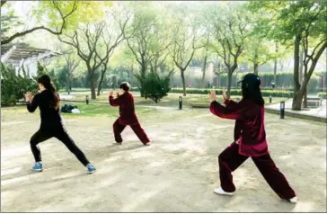  ?? ADAM DEAN/THE NEW YORK TIME ?? Women practise Tai Chi in Ritan Park in Beijing on April 15.