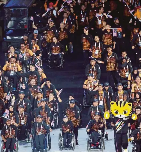  ?? PIC BY OSMAN ADNAN ?? Malaysian athletes, led by Sea Games mascot Rimau, at the closing ceremony yesterday. PIC BY LUQMAN HAKIM ZUBIR
Front page caption: Malaysian athletes in jovial mood at the closing ceremony yesterday.