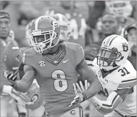  ?? John Bazemore/AP ?? Georgia wide receiver Riley Ridley (8) makes a one-handed catch as Auburn defensive back Javaris Davis (31) defends in he first half.