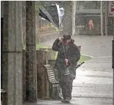  ?? GRANT MATTHEW/STUFF ?? A man loses control of his umbrella in the bad weather.