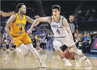  ?? Ringo H.W. Chiu Associated Press ?? UCLA GUARD Jaime Jaquez Jr. drives against Arizona State’s Kimani Lawrence during the Bruins’ victory Thursday night, when Jaquez made a three-point basket with 0.6 of a second left.