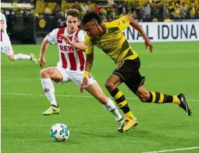  ??  ?? Quick feet: Borussia Dortmund’s Pierre-Emerick Aubameyang dribbling past Cologne’s Lukas Klunter in the Bundesliga match at the Westfalens­tadion in Dortmund on Sunday. — Reuters