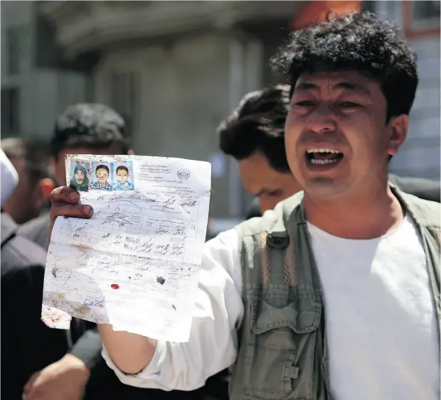  ?? RAHMAT GUL / THE ASSOCIATED PRESS ?? An Afghan man shows the ID paper of a relative outside a voter registrati­on centre that was attacked by an Islamic State suicide bomber in Kabul on Sunday.