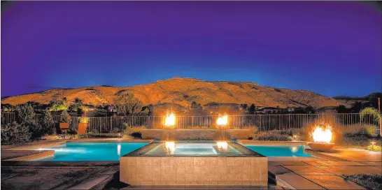  ?? Premier Pools and Spas ?? This geometric pool has fire features and a spa. Many homeowners are looking to create a backyard living space as an extension of the home.