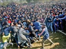  ?? REUTERS ?? A man wields a stick to keep people away before offering a gun salute during the funeral procession of slain terrorist Sabzar Ahmad Sofi, who was killed in a gun battle with security forces on the outskirts of Srinagar, in Sangam town of South Kashmir on Wednesday.