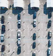  ?? MARK MULLIGAN/HOUSTON CHRONICLE ?? Cars line up Wednesday in a parking lot in Houston as people wait for a vaccine.