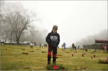  ?? LAUREN A. LITTLE — MEDIANEWS GROUP ?? Ben Wright, 12, of Exeter, was among the volunteers Dec. 14 during Wreaths Across America at Forest Hills Memorial Park in Exeter Township.