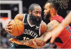  ?? FRANK GUNN/THE CANADIAN PRESS VIA AP ?? Brooklyn Nets guard James Harden (13) drives to the net as Toronto Raptors guard Gary Trent Jr., right, defends during second the half on Sunday. Harden scored 28 points in the Nets’ 116-103 win.