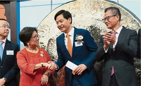  ??  ?? Xiaomi debut: Xiaomi chairman and CEO Lei Jun being greeted by Laura Cha, chairman of of Hong Kong Exchanges and Clearing Ltd (HKEX), as HKEX deputy chairman of listing committee John Ho (left) and Hong Kong Financial Secretary Paul Chan look on during...