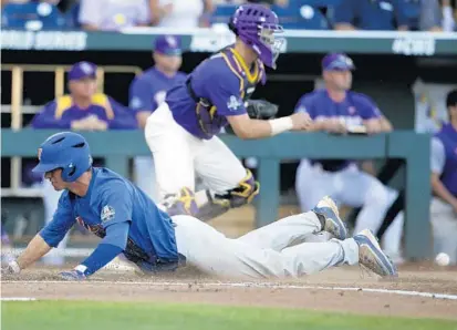  ?? NATI HARNIK/ASSOCIATED PRESS ?? UF’s Dalton Guthrie scores on a ground-rule double in the 4th inning of Game 1 Monday in the College World Series finals series against LSU.