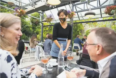  ?? Brittany Hosea-Small / Special to The Chronicle ?? Jessica Shen talks with guests Kathy Dumbleton and John Flanagan at Abstract Table in Berkeley. Owner Andrew Greene is considerin­g barring diners who are unvaccinat­ed.