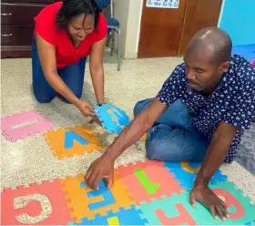  ?? (Photos: Kasey Williams) ?? Simone Thomas and her husband Lancelot work on putting together this play mat at their home