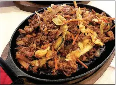  ?? Arkansas Democrat-Gazette/ERIC E. HARRISON ?? Jeyuk Bokkeum, spicy ground pork stir-fried with vegetables and served on a skillet, is among the Korean Specials at Kimchi on South University Avenue in Little Rock.